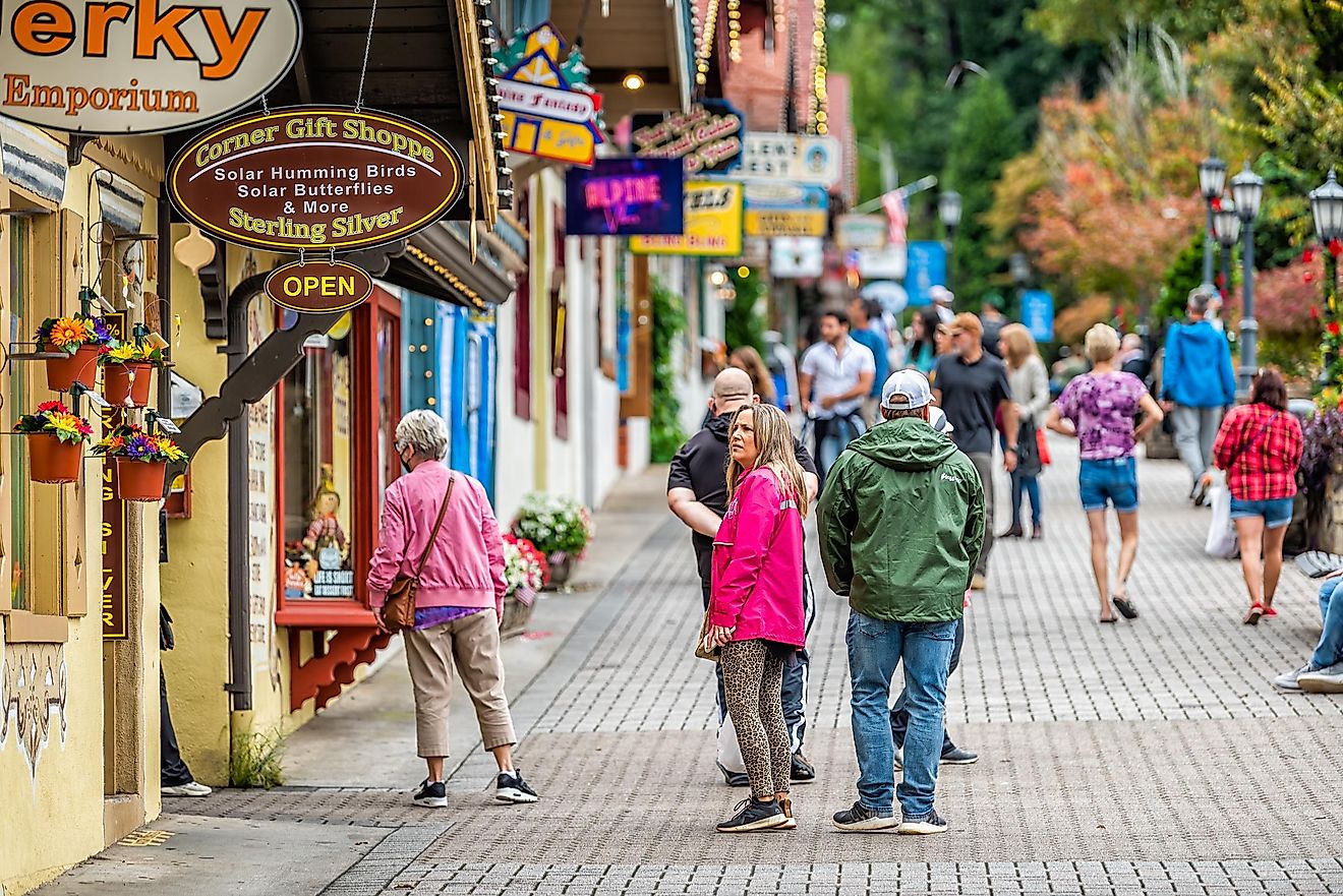 Helen, Georgia Bavarian village town traditional architecture building with many people tourists and sign for corner gift shop stores on Main street cobbled sidewalk