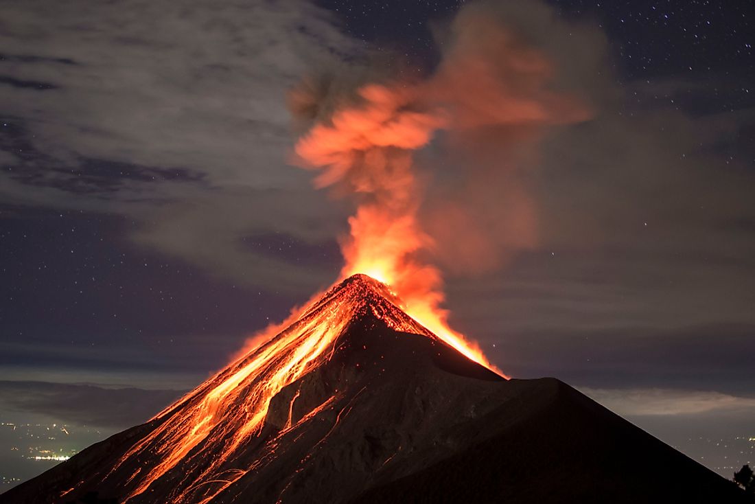 A volcanic eruption with lava flowing down the side of the mountain.