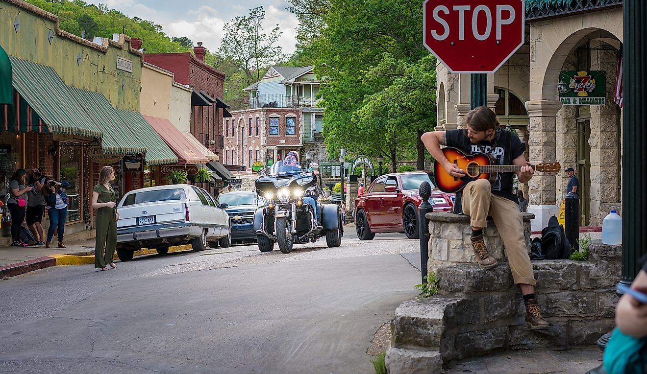  A man playing a guitar in the downtown area of Eureaka Springs, Arkansas. Editorial credit: shuttersv / Shutterstock.com