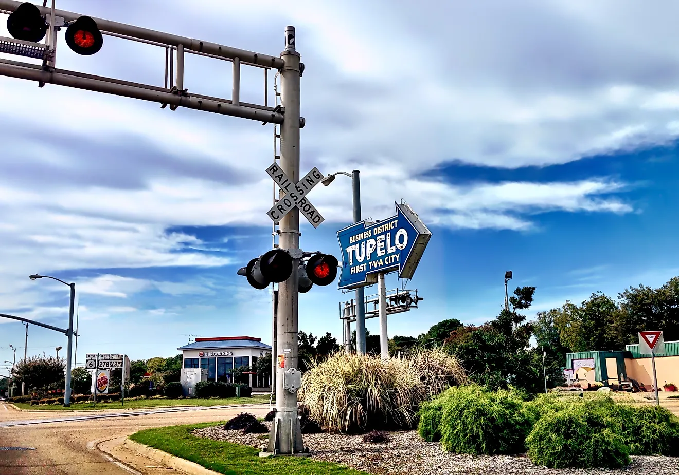 Business District sign and railroad crossing in Tupelo, Mississipi. Via Shutterstock / Lucideye-James Walker.