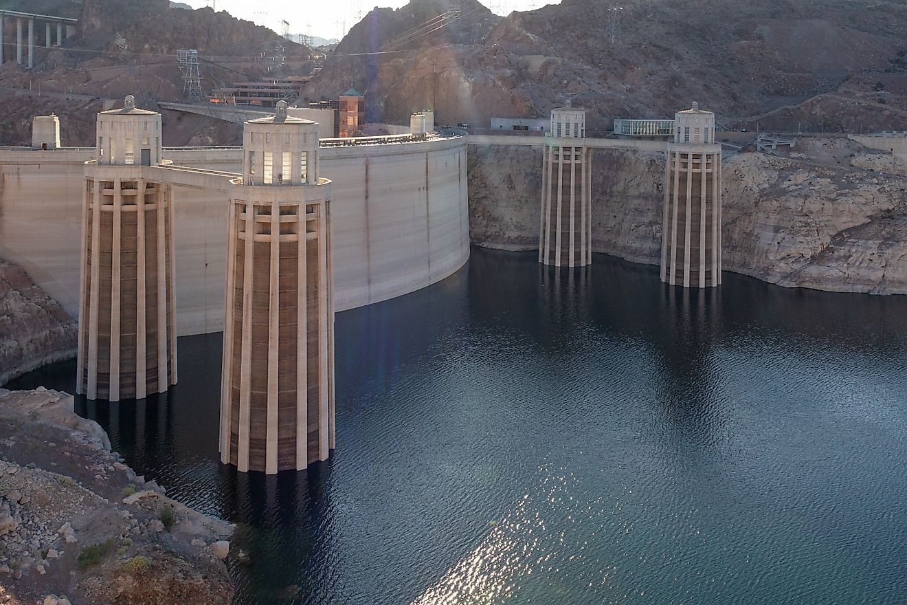 Detailed view of the Hoover Dam intake towers standing above the Colorado River, showing water levels and surrounding rocky desert terrain