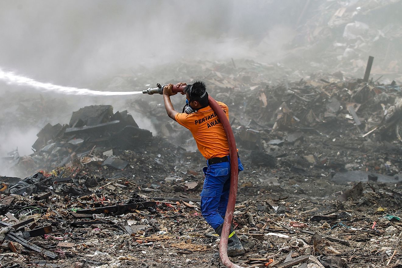 The Malaysian Civil Defence Department personnel trying to extinguish the fire at illegal dumpsites in Seri Kembangan, Selangor. Image credit: Lens Hitam/Shutterstock.com