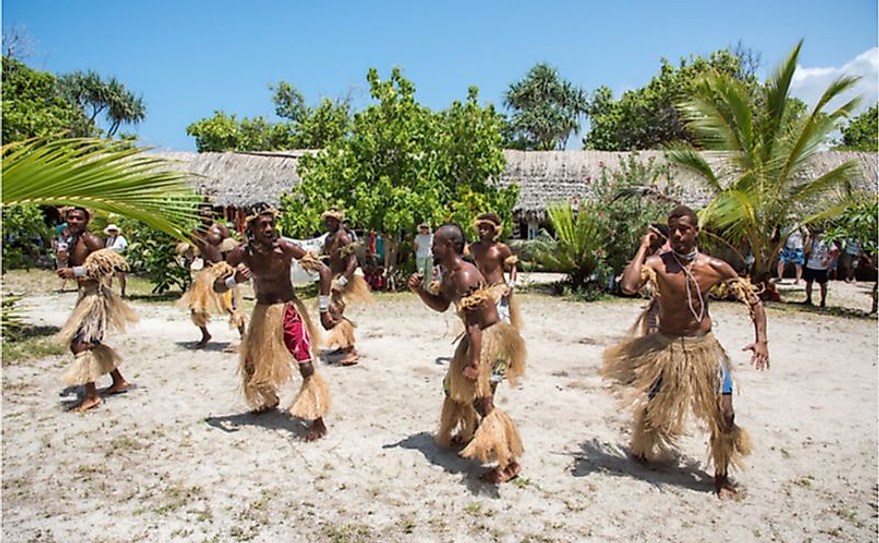 Vanuatu's men dancing in traditional costume with tourists on Mystery Island. Editorial credit: EA Given / Shutterstock.com