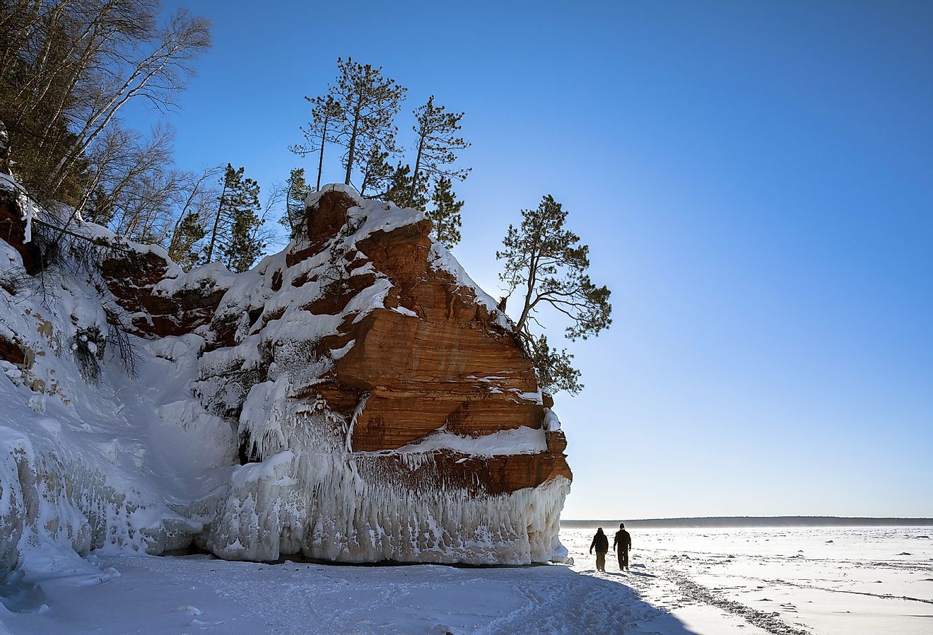 Hikers on the ice-laden sandstone cliffs on Wisconsin's Apostle Islands National Lakeshore near Meyer's beach; Lake Superior.