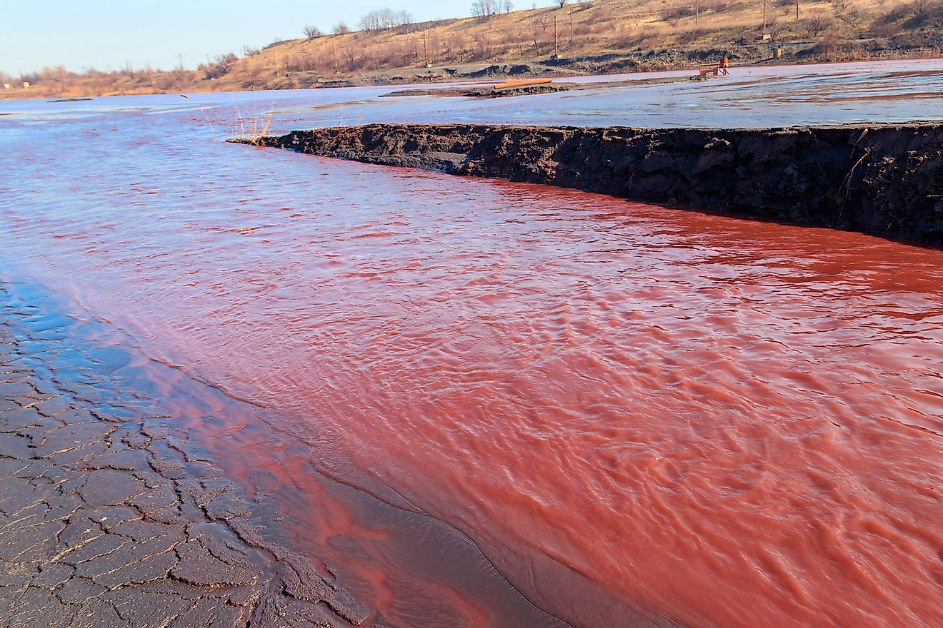Red water polluted with iron ore waste discharged after the iron ore beneficiation in Kryvyi Rih, Ukraine. Image credit: Olha Solodenko/Shutterstock.com