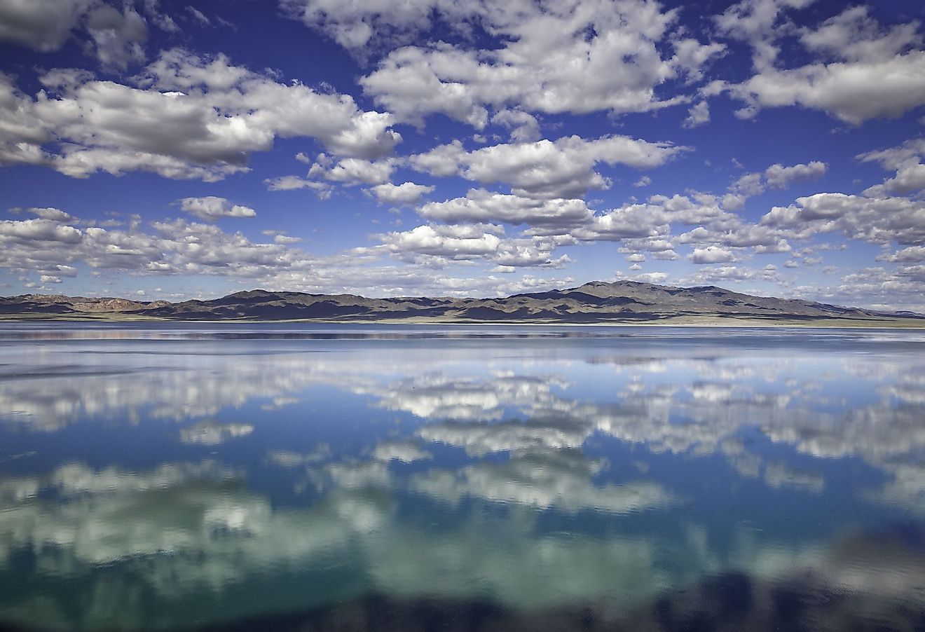 Reflections of blue skies and white puffy clouds in Walker Lake, Nebraska. 