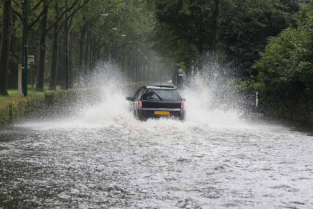 A car driving through a flooded street in the Netherlands. 