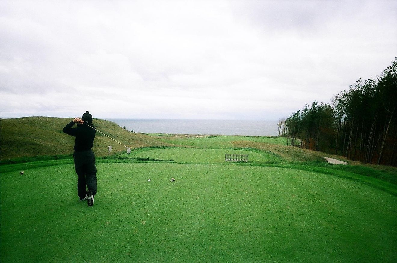 A golfer hitting a tee shot at Arcadia Bluffs Golf Club in Arcadia, Michigan. Editorial credit: Matthewwlloyd - Own work, CC BY 3.0, via Wikimedia Commons