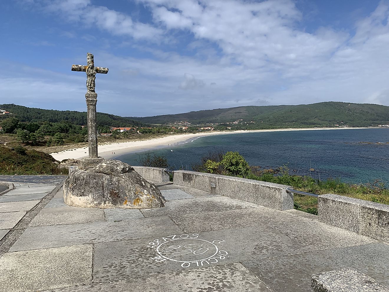 A stone cross stands above a quiet beach in Fisterra, Spain. Photo: Andrew Douglas.
