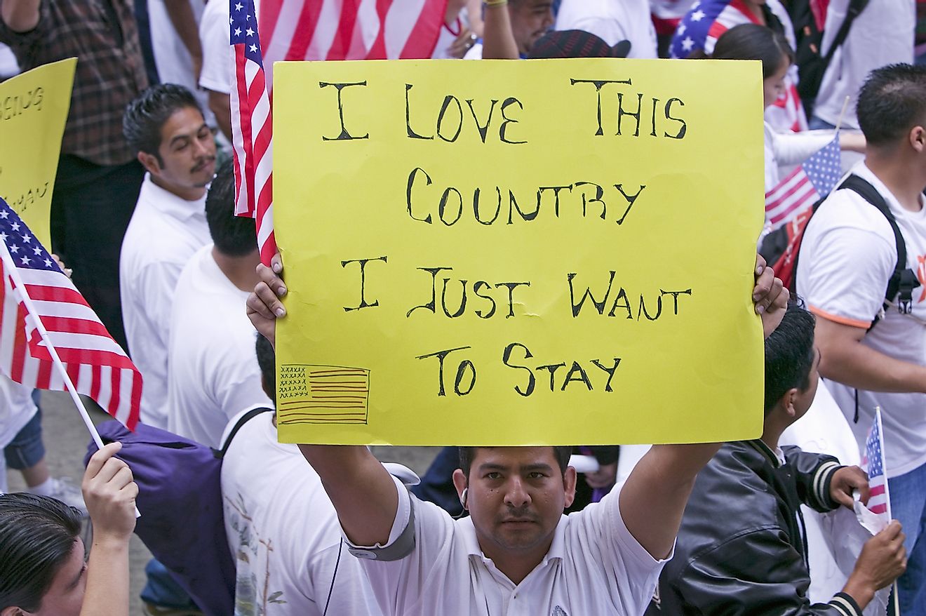 Man holds sign saying "I love this country" in march for Immigrants and Mexicans protesting against Illegal Immigration reform by U.S. Congress, Los Angeles, CA, May 1, 2006. Image credit: Joseph Sohm/Shutterstock.com