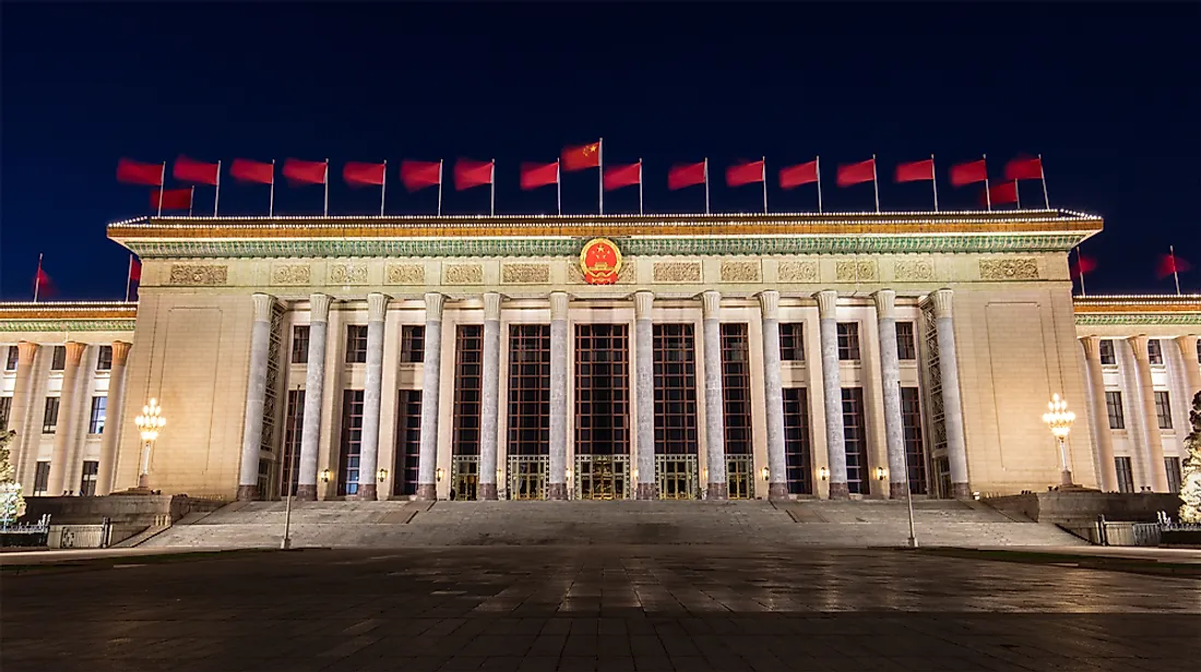 China's Great Hall of the People adorned with Chinese flags and emblem.