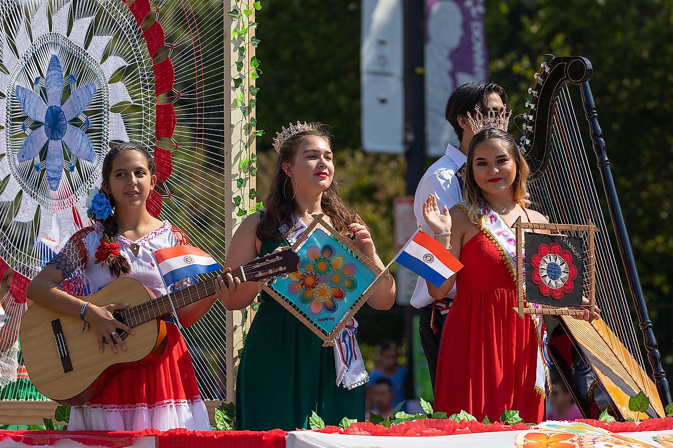 Young Paraguayan woman, wearing Ninduti dress playing the guitar. Image credit: Roberto Galan/Shutterstock.com