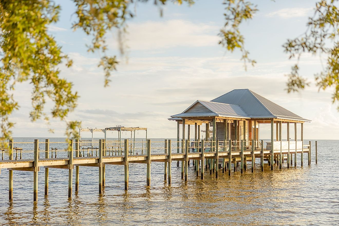 A scenic view of a peaceful lake with a pier and lush surroundings in Fairhope, Alabama.