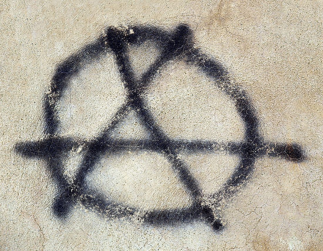The anarchy symbol spray-painted on a wall. 