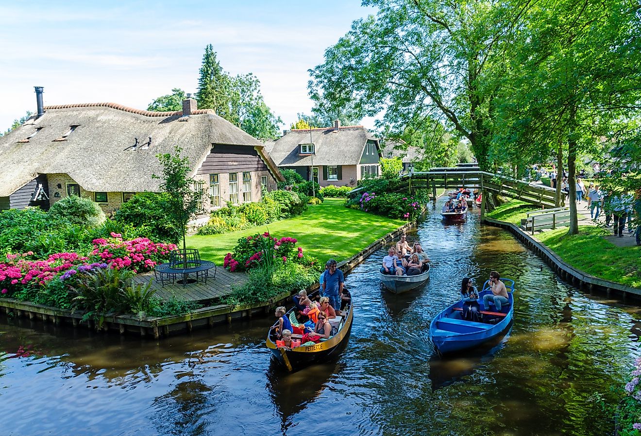 Folks cruising on the canals in Giethoorn, Netherlands. Editorial credit: rob3rt82 / Shutterstock.com