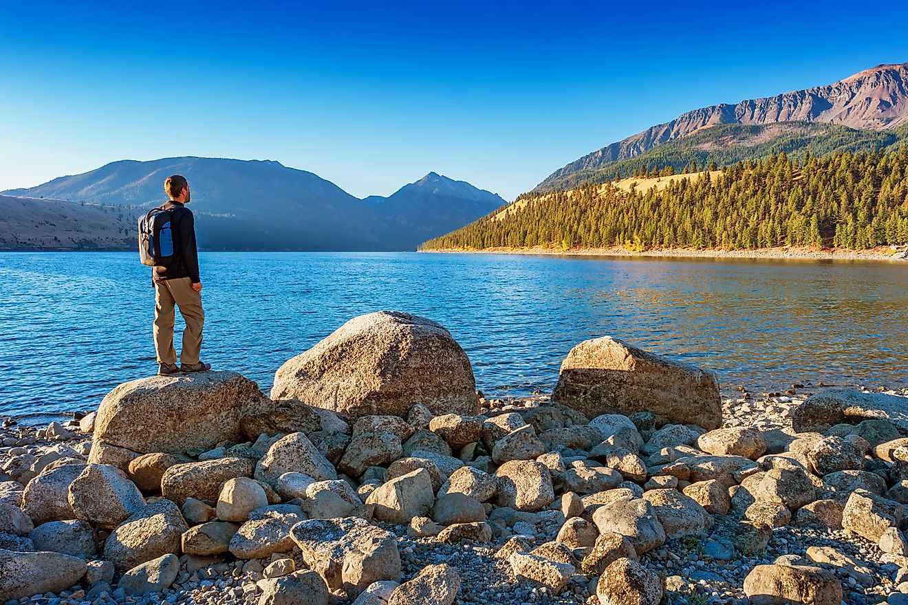 Hiker looks at view at Wallowa Lake and Wallowa Mountains near Joseph, Oregon. 