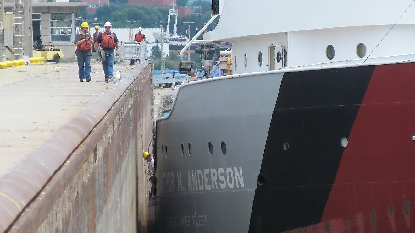 A crew member and shoreside line handlers help guide the Great Lakes freighter Arthur M. Anderson into the Poe Lock at Sault Ste. Marie, Michigan. 