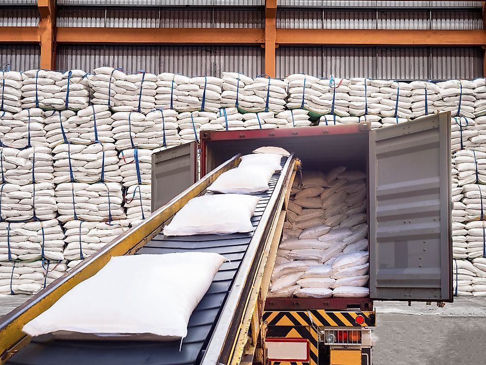 Bags of white sugar leave the warehouse.