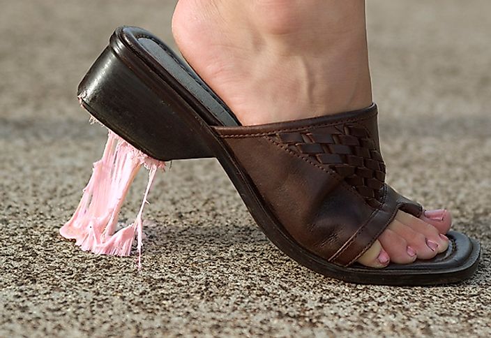 Woman steps in gum on street.