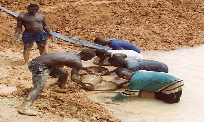 Diamond miners in Sierra Leone sifting through the sand in search of diamonds.