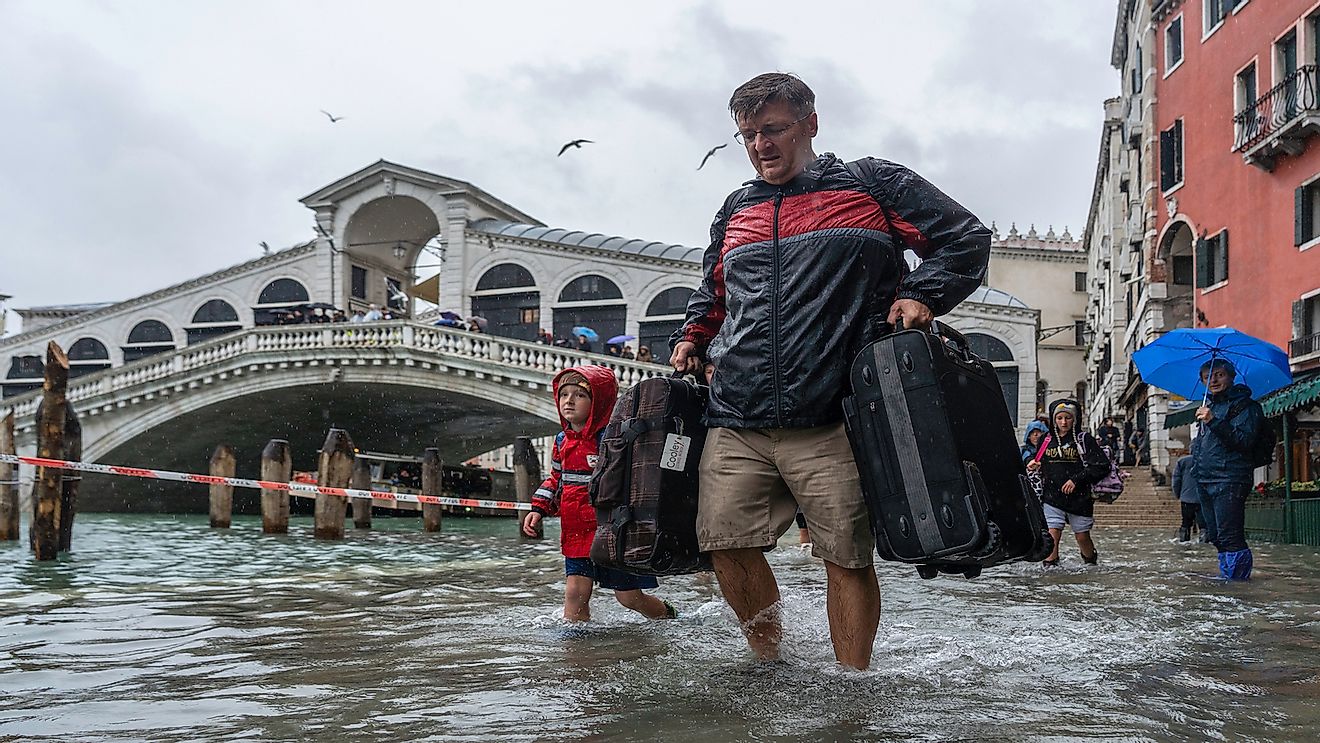 Tourists in Venice during a flood. Editorial credit: Ihor Serdyukov / Shutterstock.com.