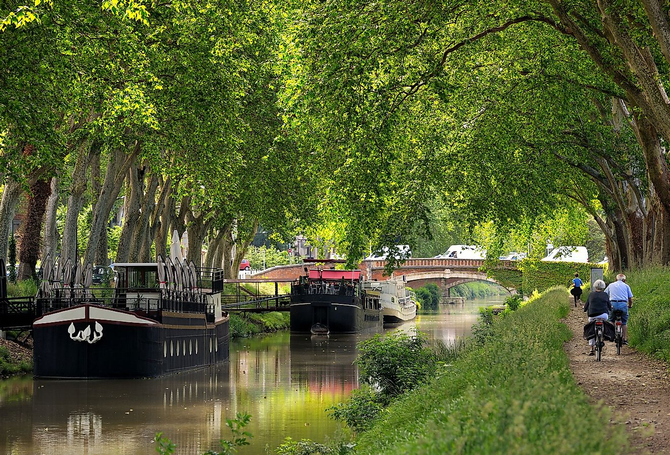 Cyclists and pedestrians line the Canal du Midi. Image credit thieury via Shutterstock.
