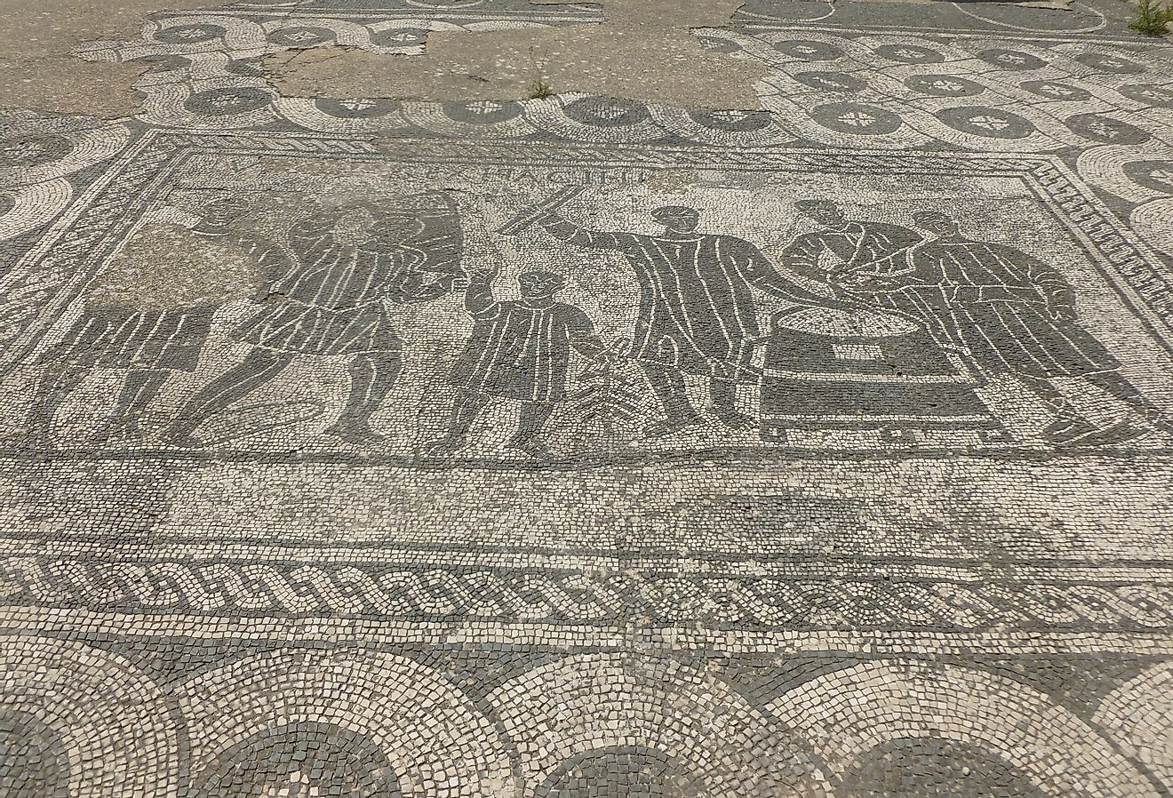 Black-and-white mosaic; depicted are grain measurers (mensores frumentarii) at work. Image credit MumblerJamie, CC BY-SA 2.0 <https://creativecommons.org/licenses/by-sa/2.0>, via Wikimedia Commons