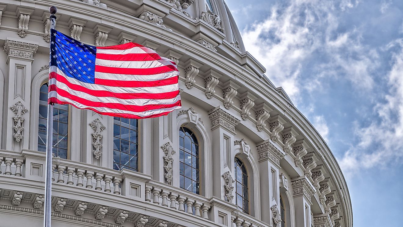 Washington DC Capitol dome with waving American flag.