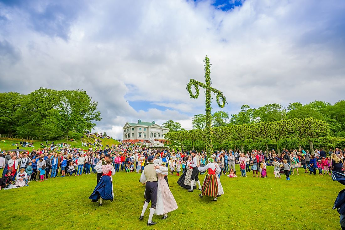 Dancers in traditional attire partake in Midsummer celebrations in Sweden. Editorial credit: Fotos593 / Shutterstock.com.
