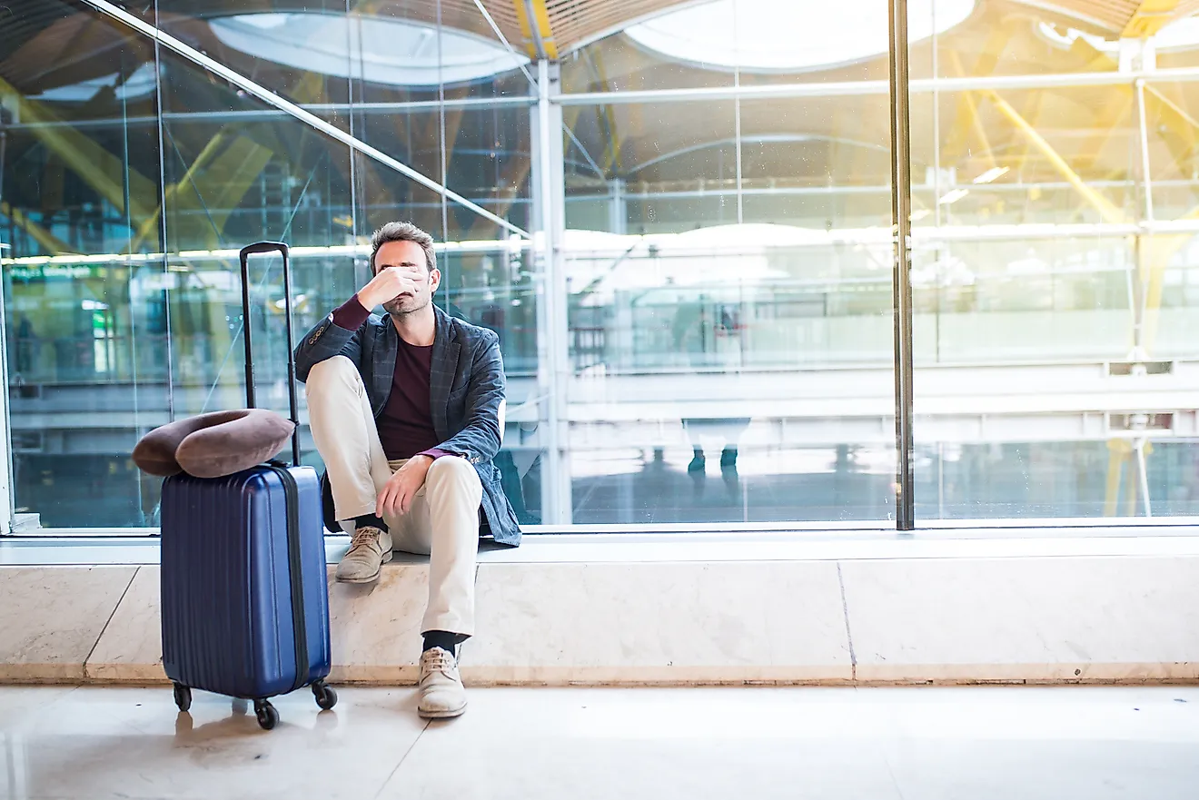 A man upset at the airport due to delayed flight.