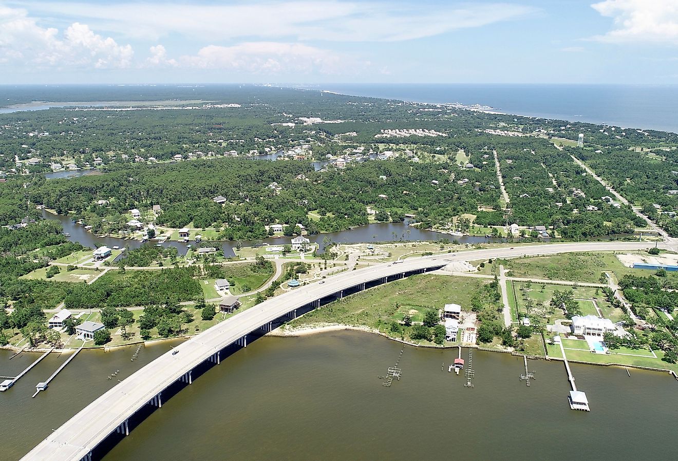 A curved highway on St Louis Bay enters land with piers on both sides.
