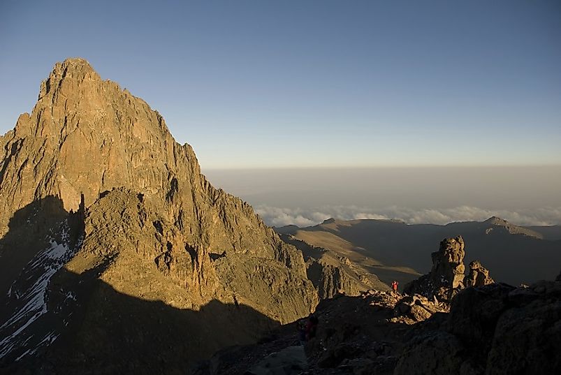 Note the man in the red shirt and others in the shadows (bottom right corner), dwarfed even by just the very peak of Mount Kenya.