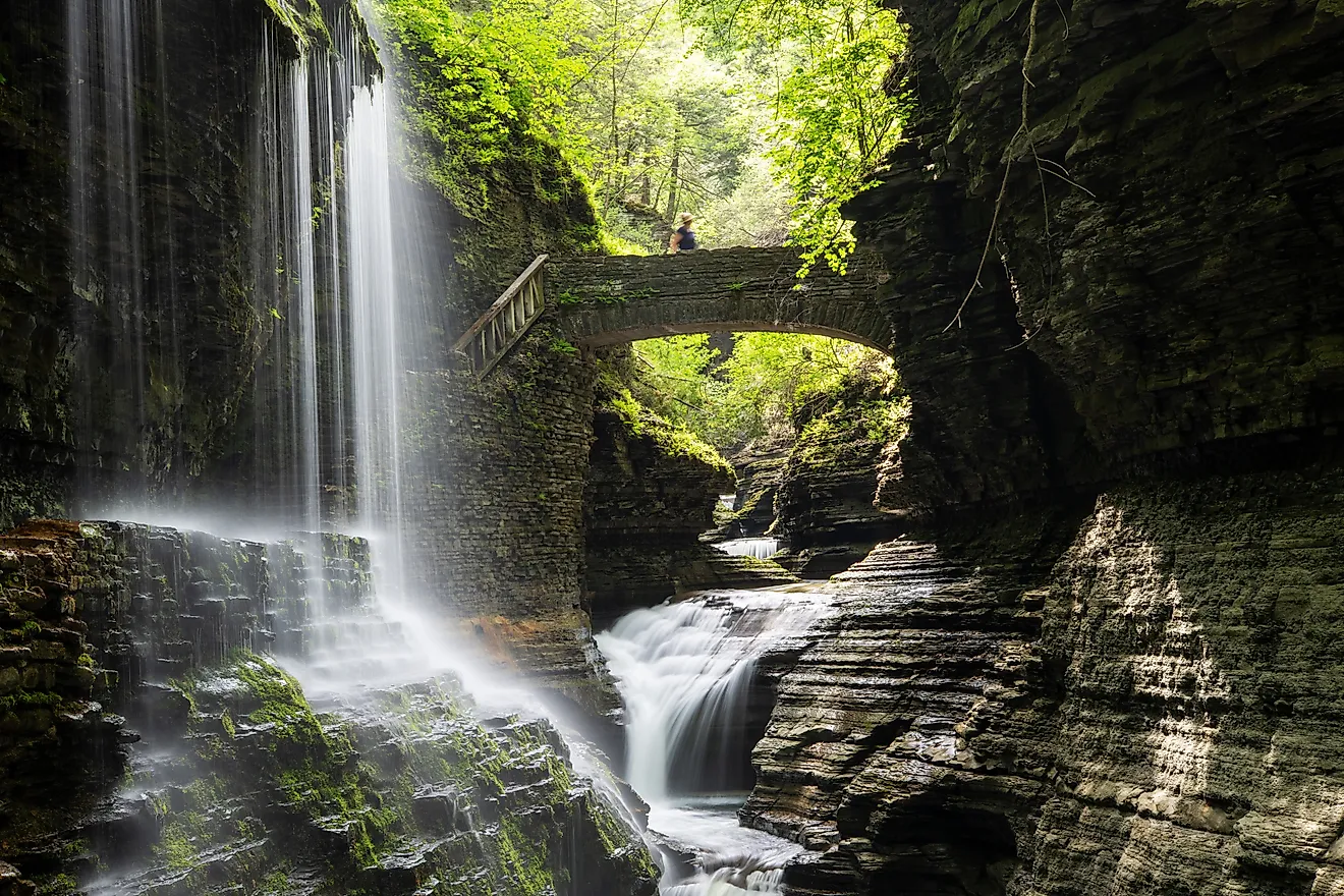 Rainbow Falls with a lady on bridge at Watkins Glen State Park