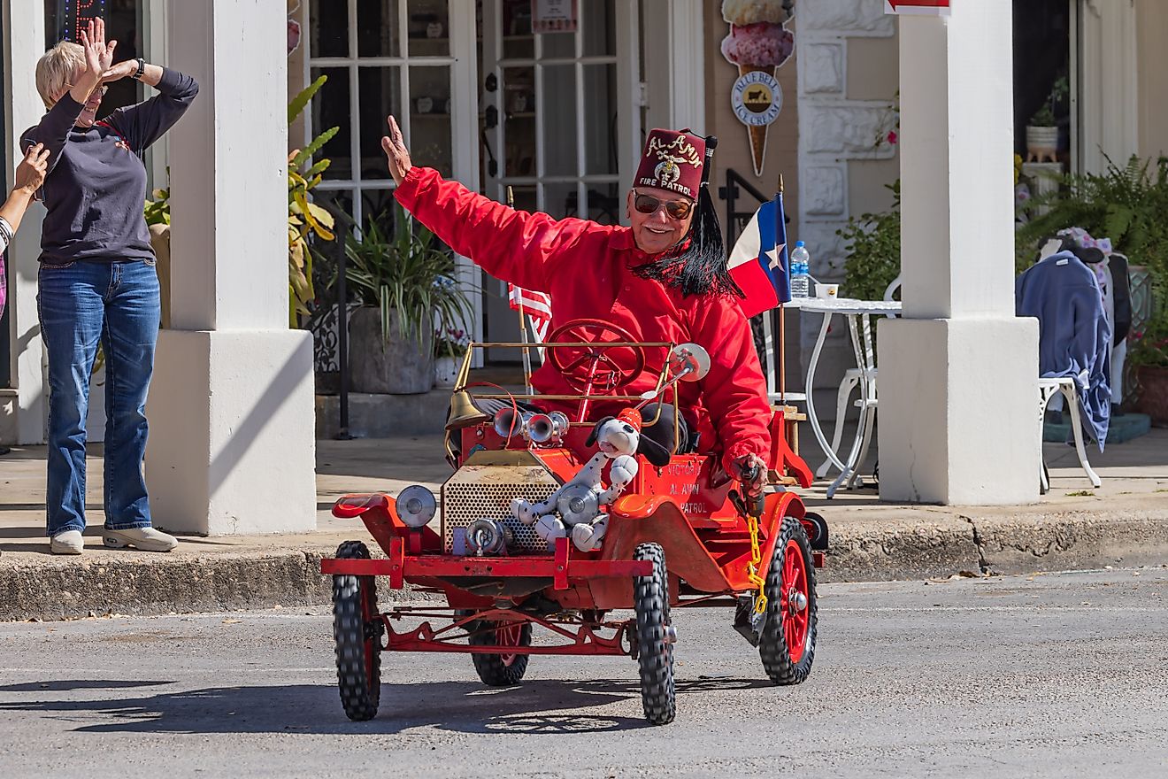 Goliad, Texas, United States. A Shriner driving a minature car shaped like an antique fire truck in a small town parade. Editorial credit: Emily Marie Wilson / Shutterstock.com