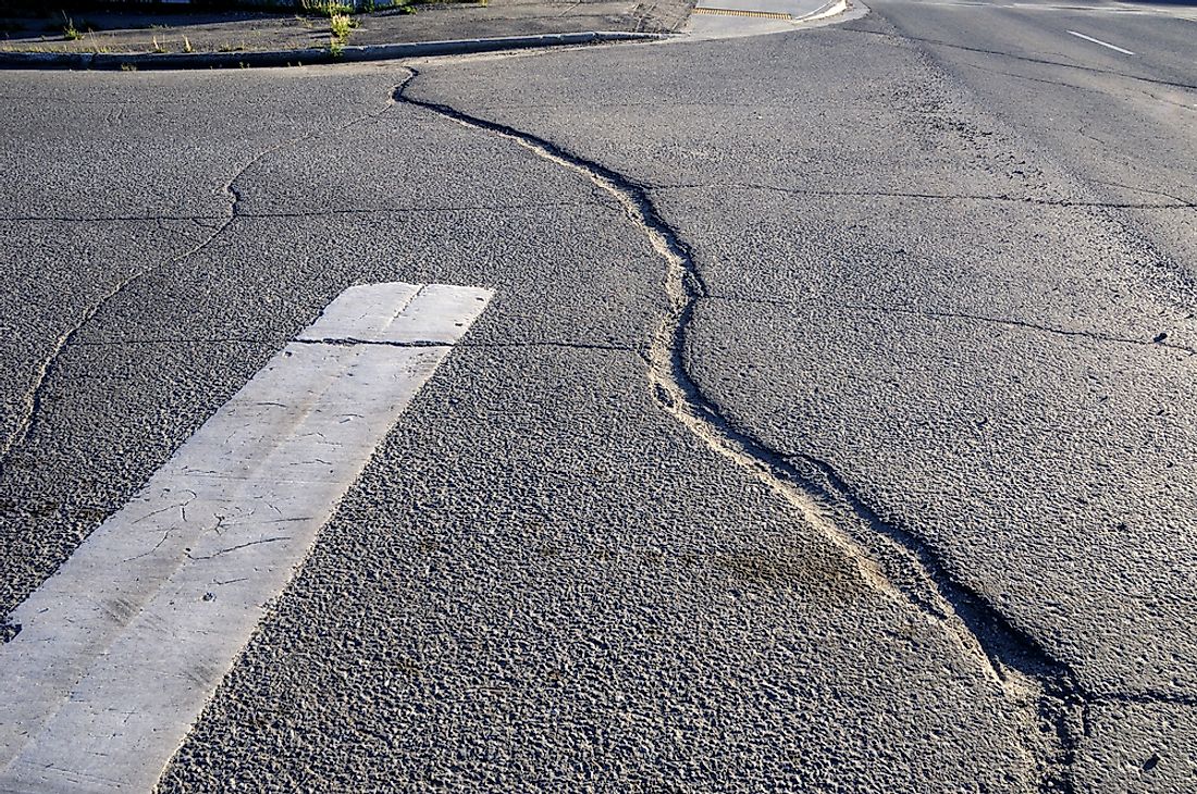 A crack in the pavement of a city street. 