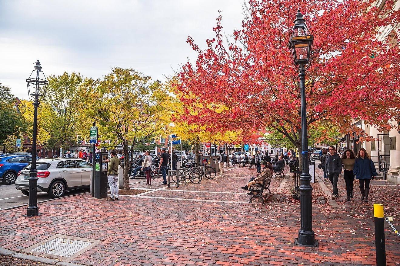 People enjoying a warm autumn afternoon in a small brick square along Pleasant Street in downtown. Portsmouth is a New Hampshire port city on the Piscataqua River.