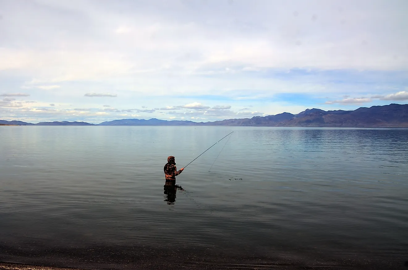 A fisherman fishing in Pyramid Lake which is a large natural lake and a world-class fishery in Nevada. Pyramid Lake, Nevada, United States Editorial credit: Daniel L. Locke / Shutterstock.com