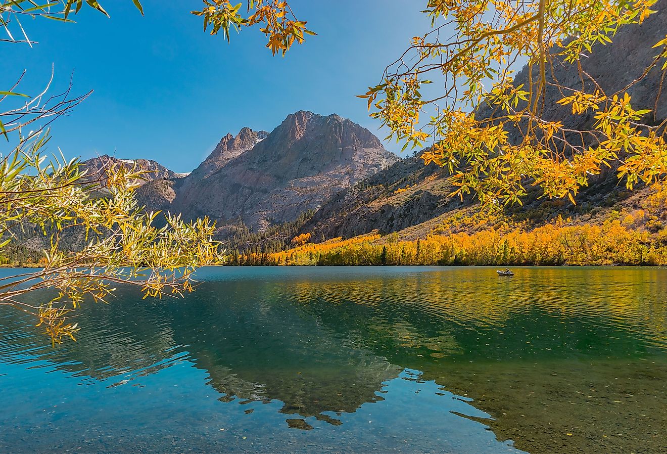 Willow and Aspen trees are golden in Autumn and surround Silver Lake at June Lake Loop in the Californian Sierra Nevada mountains of California