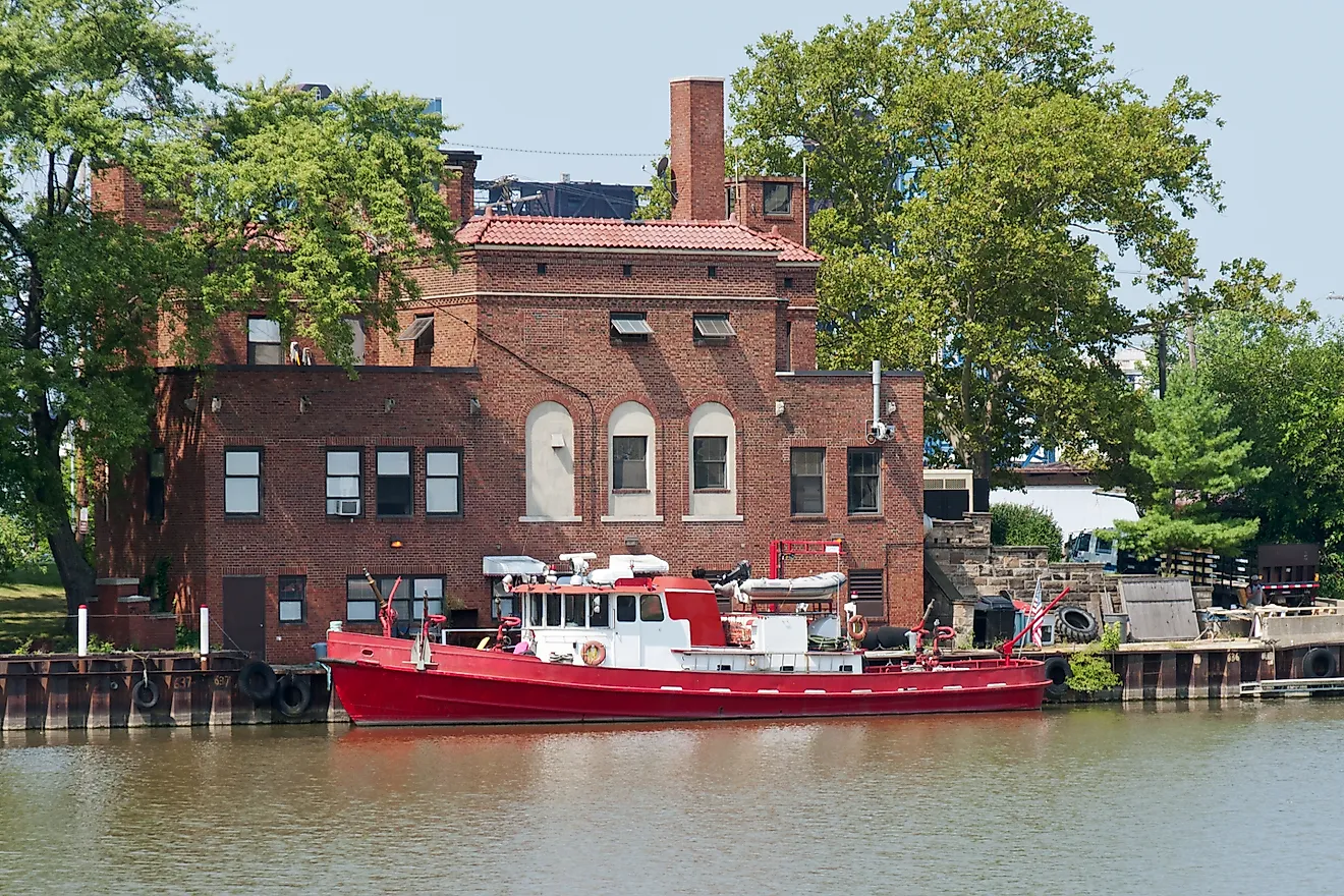 Fire Boat on the River A boat equipped for fire fighting is docked at a brick fire station on the Cuyahoga River in Cleveland, Ohio. 