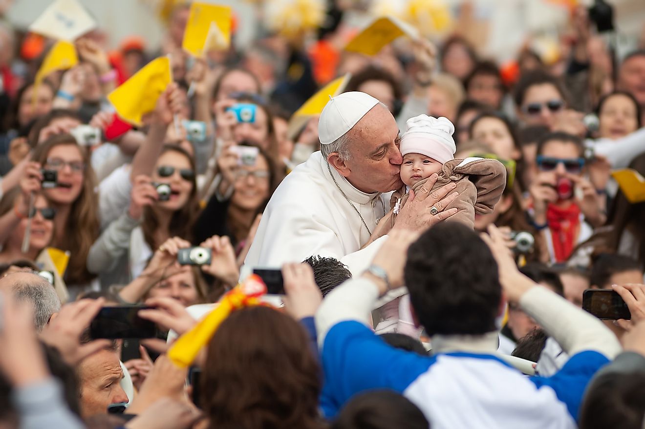 His Holiness Pope Francis I kisses a child during a prayer in front of St Peter' Basilica in Vatican City. Image credit: Boris Stroujko/Shutterstock.com