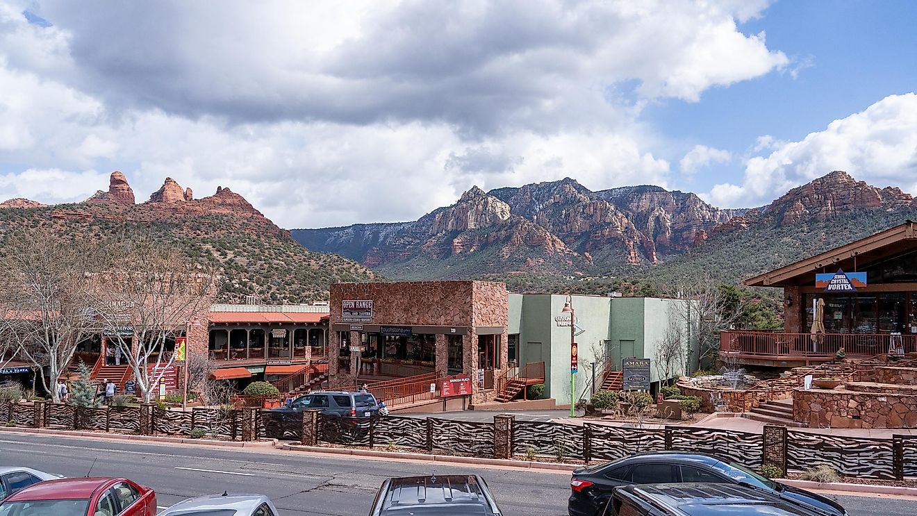 View of buildings in downtown Sedona, Arizona with towering mountains in the backdrop. Editorial credit: Red Lemon / Shutterstock.com