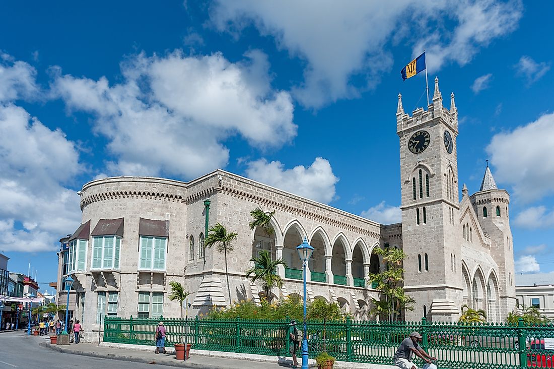 Flag of Barbados flying above the Parliament Buildings of Bridgetown, Barbados.  Editorial credit: photosounds / Shutterstock.com
