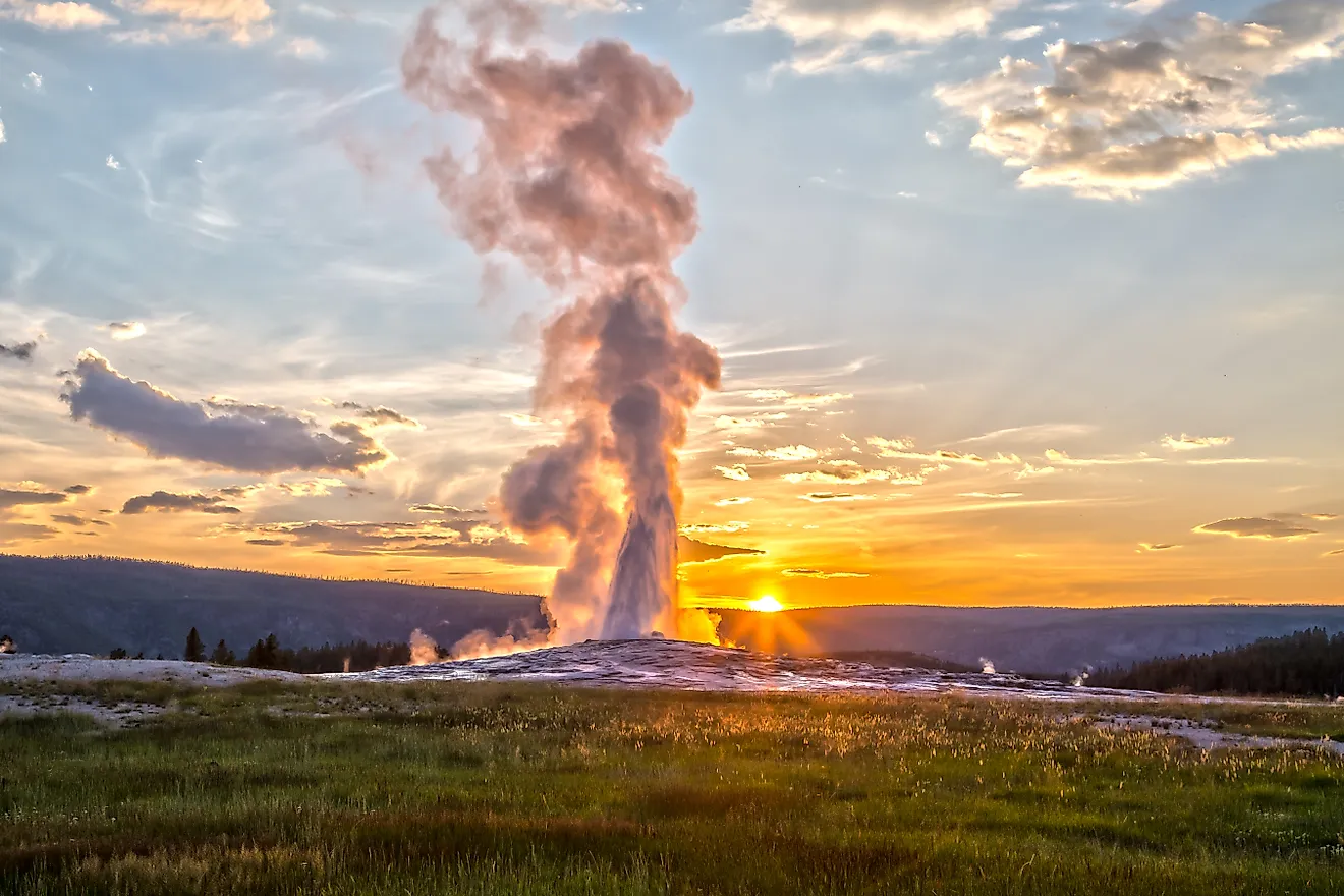 Old Faithful Geyser Eruption in Yellowstone National Park at Sunset. 