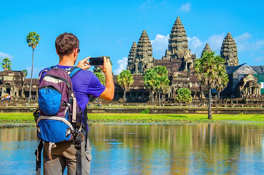 A tourist takes a photo at Angkor Wat. 