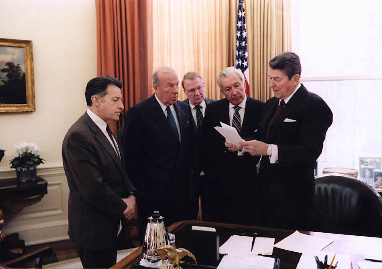President Ronald Reagan with Caspar Weinberger, George Shultz, Ed Meese, and Don Regan discussing the President's remarks on the Iran-Contra affair, Oval Office. Image credit: White House Photo Office/Public domain
