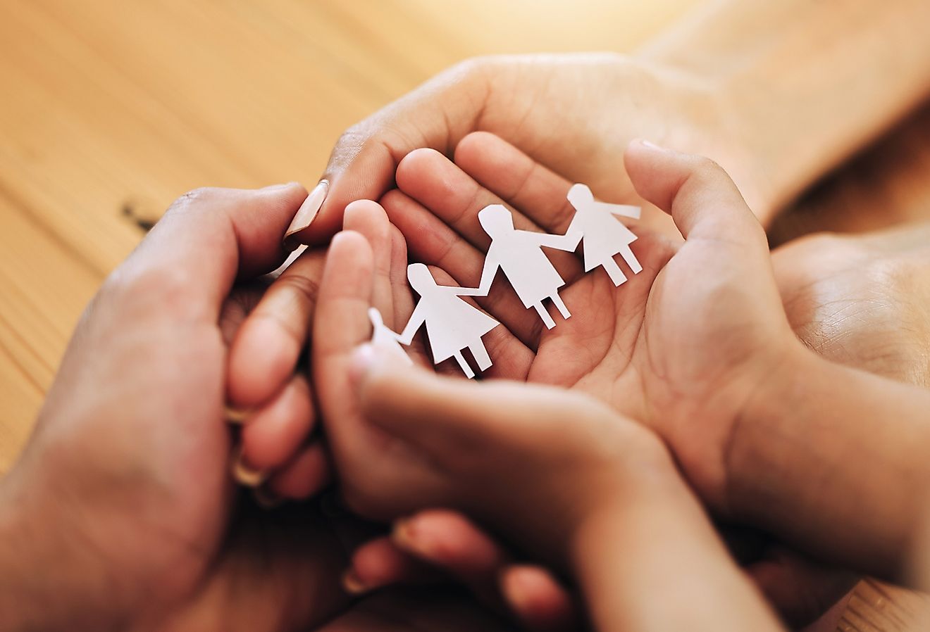 Paper cut outs of a family held in the palm of hands. Concept of what is a family?