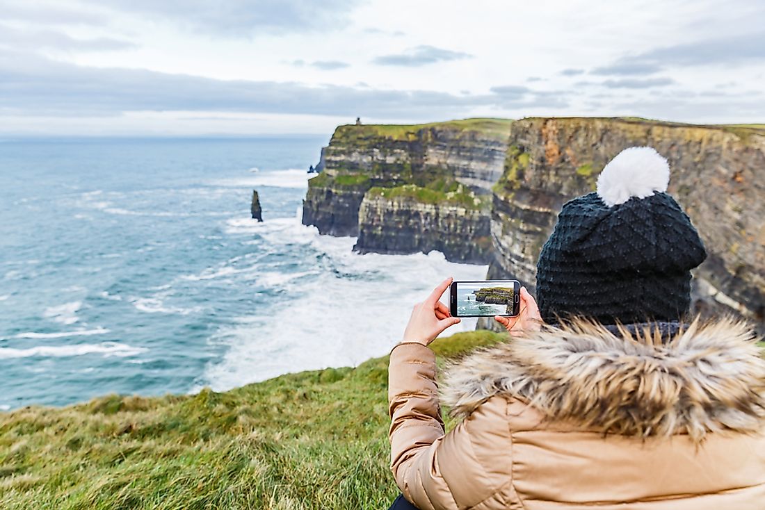 A tourist enjoying Ireland at the Cliffs of Moher. 