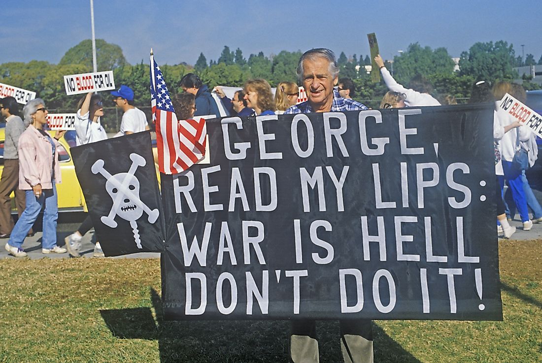 A man poses with a sign protesting the Iraq War. Editorial credit: Joseph Sohm / Shutterstock.com.