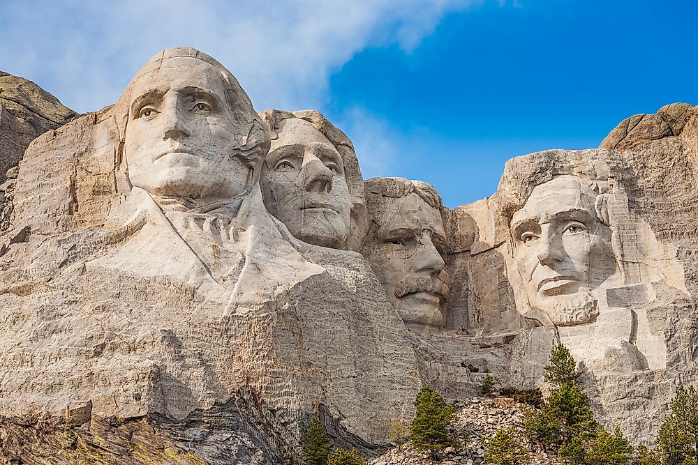 Mount Rushmore sculptures of past-presidents George Washington, Thomas Jefferson, Theodore Roosevelt, and Abraham Lincoln.