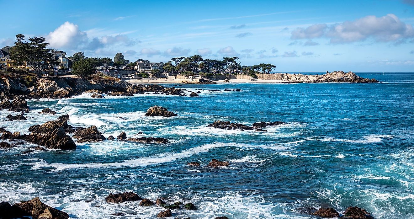 Waves splash on the rocky coast along the Monterey Bay in Pacific Grove, California on a windy winter day. 